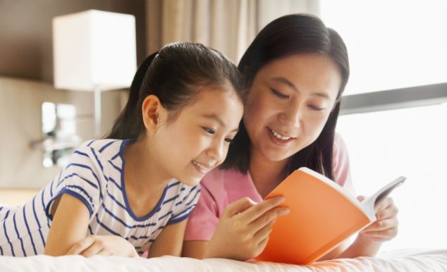 Chinese mother and daughter reading together